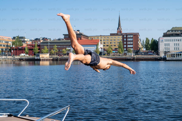 Man diving into harbor on a summer day