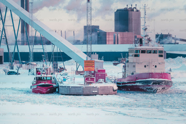 Tugboats at industrial harbor in winter