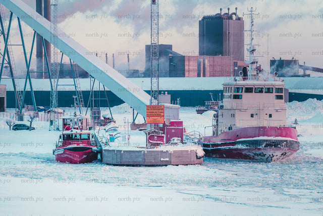 Tugboats at industrial harbor in winter