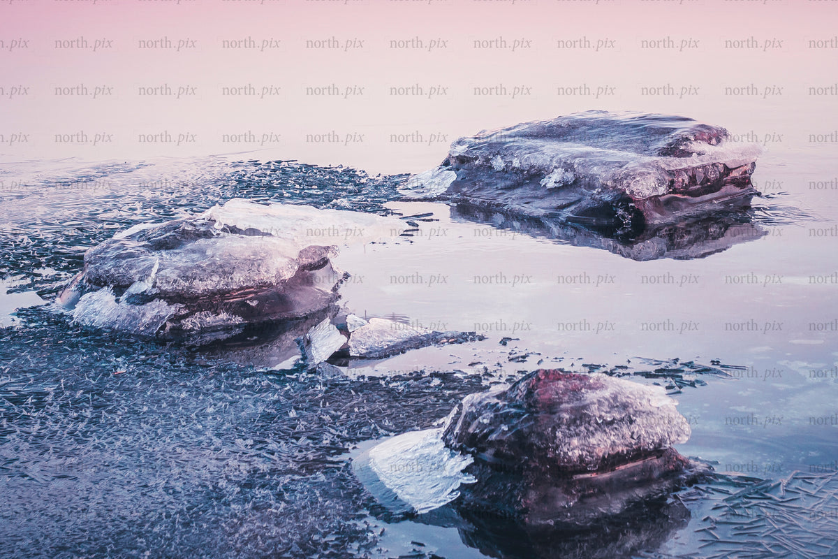 Ice formations on a partially frozen lake at sunrise