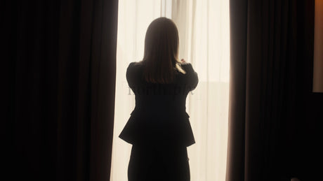 Businesswoman Opens Curtains in Hotel Room at Sunrise in Lulea