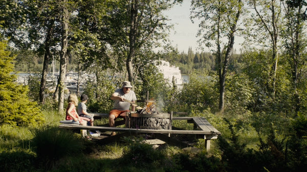 Family campfire by the water in Luleå, on a bright summer day