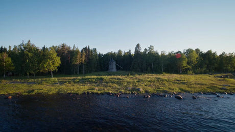 Summer Evening in Luleå Archipelago: Drone View of Windmill, Coastline, and Forest at Golden Hour