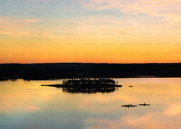 Evening paddle near forested island at sunset in Luleå