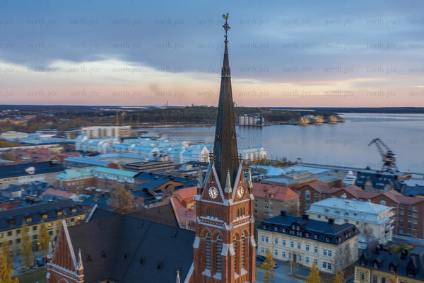 Aerial view of Luleå city center with a clock tower spire over waterfront and colorful roofs
