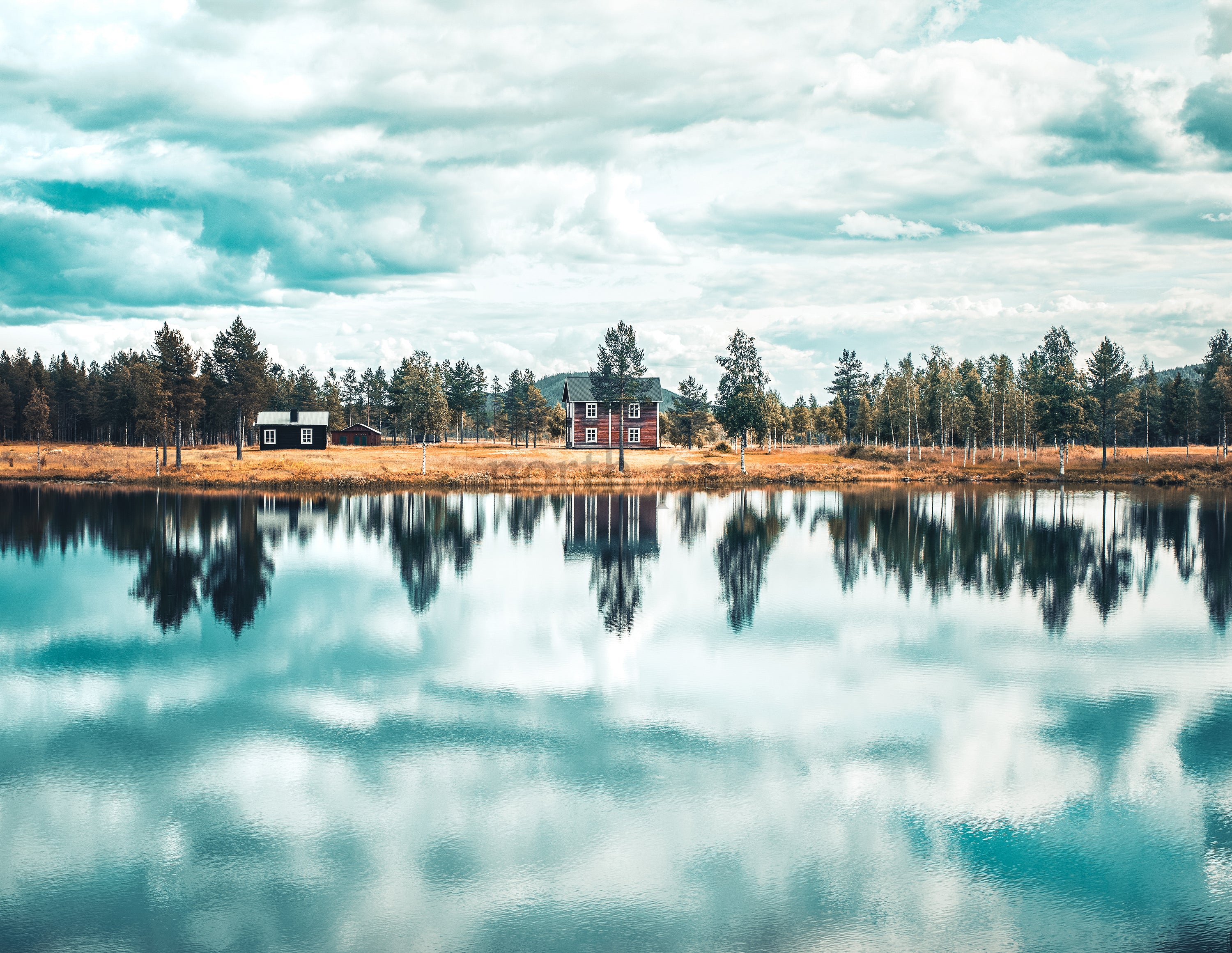 House and cabins by a lake with mirrored reflection