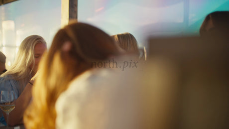 Friends Enjoy Drinks at Sunset on a Rooftop Bar in Luleå