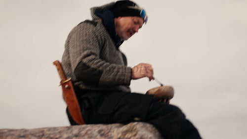 Man njuter av vintermåltid i Luleå skärgård, Sverige, från en Kuksa