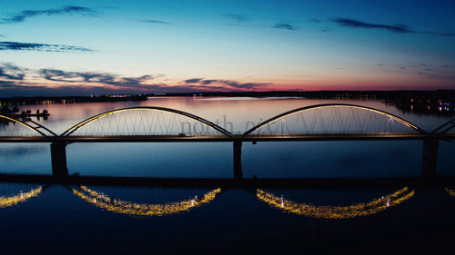 Flygfoto över Luleås Bergnäsbron i skymningen: Lugna vatten och skymningshimmel