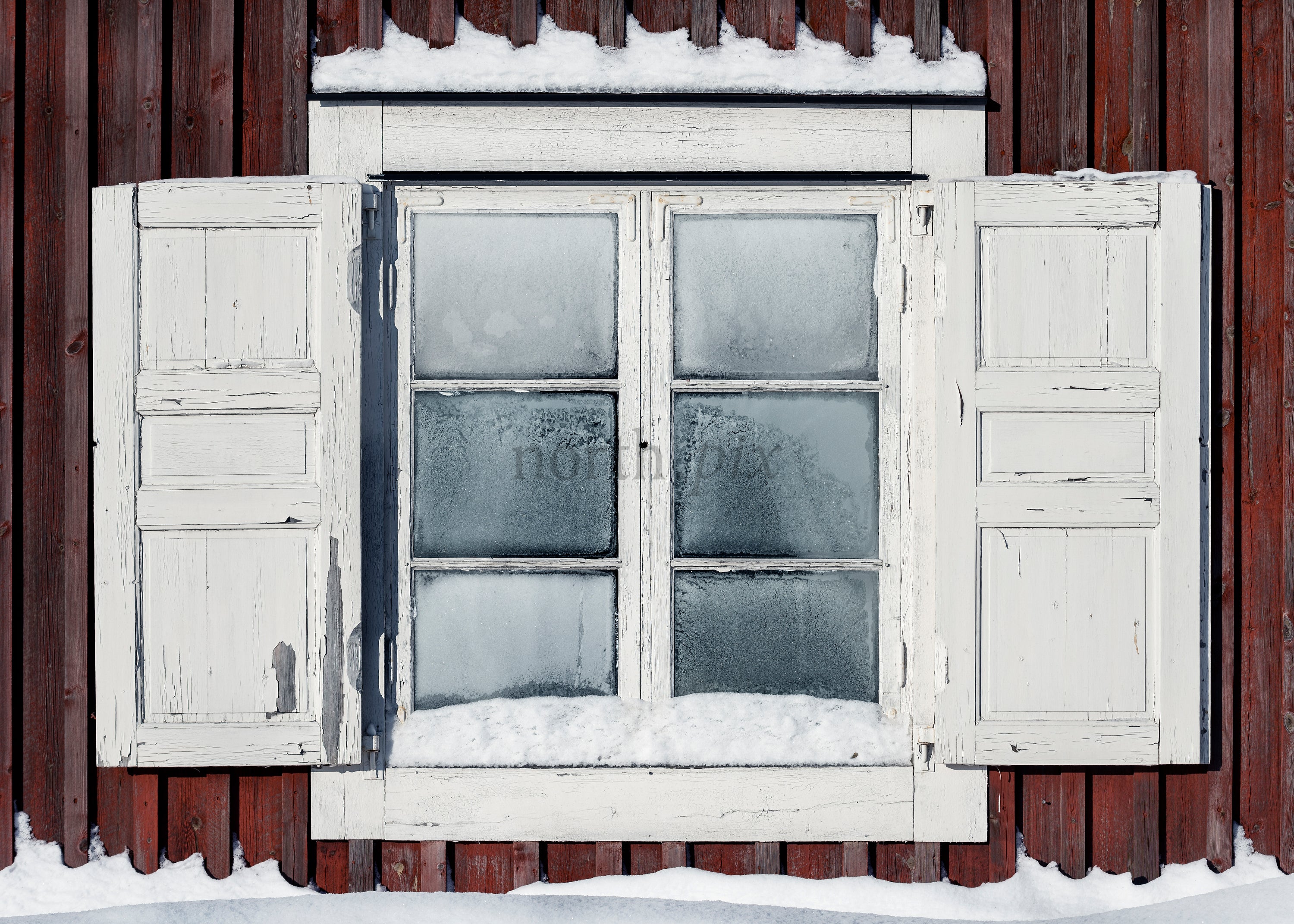 Old wooden window with shutters and snow