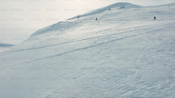 Skiers and snowboarders ascend snowy mountain at Riksgränsen ski resort