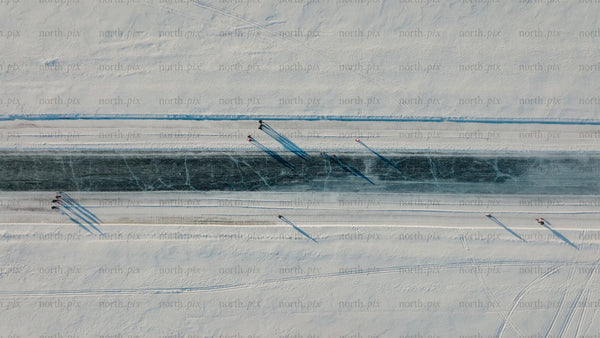 Aerial view of frozen river in Luleå with people skating and walking in winter
