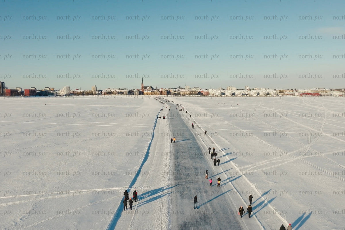 Snöiga Luleå centrum Flygfoto över frusen sjöstig och människor som går
