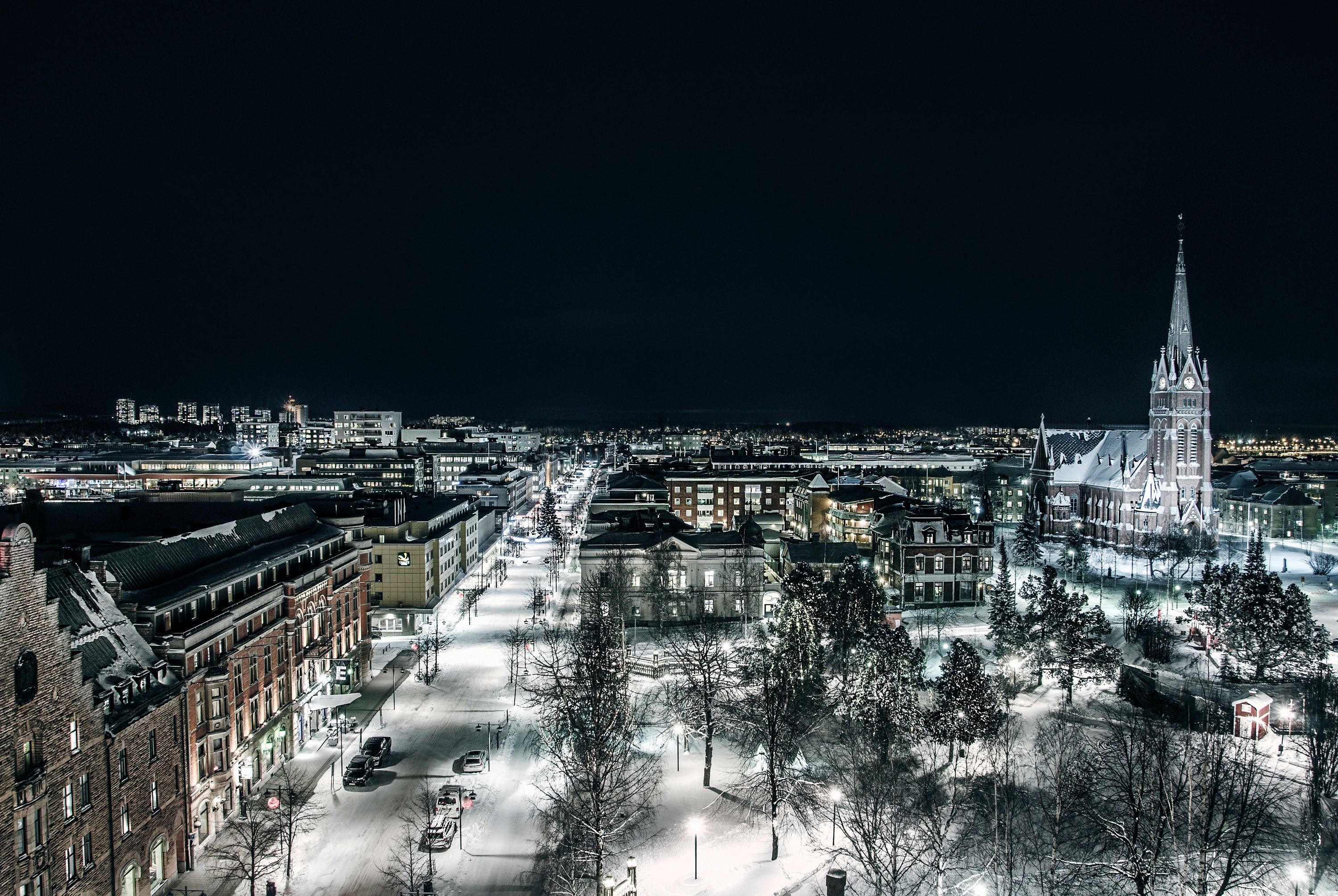 Night aerial view of snowy city with church