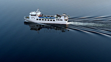 White Passenger Ferry Sails on the Lule River in Lulea, Sweden on a Summer Day