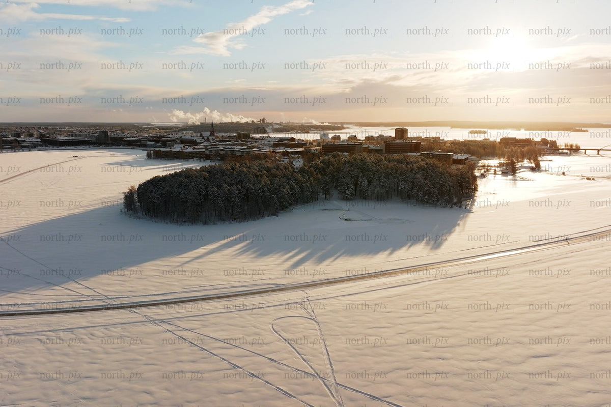 Aerial winter view over Luleå city center with snow covered island and sunset