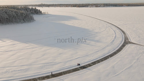 Vintersoluppgång över frusen flod i Luleå, Sverige: Flygfoto över människor som njuter av det natursköna landskapet