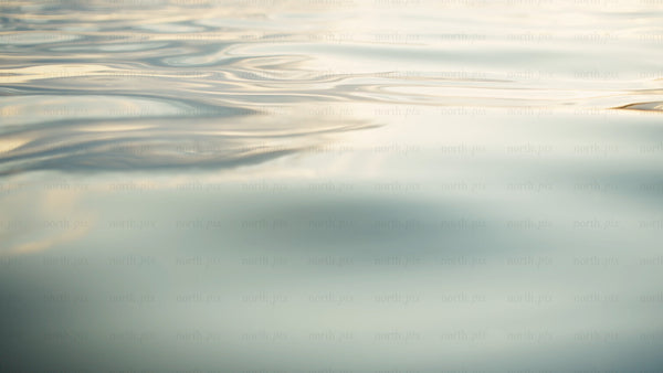 Calm water ripples at sunset: Golden hour reflections