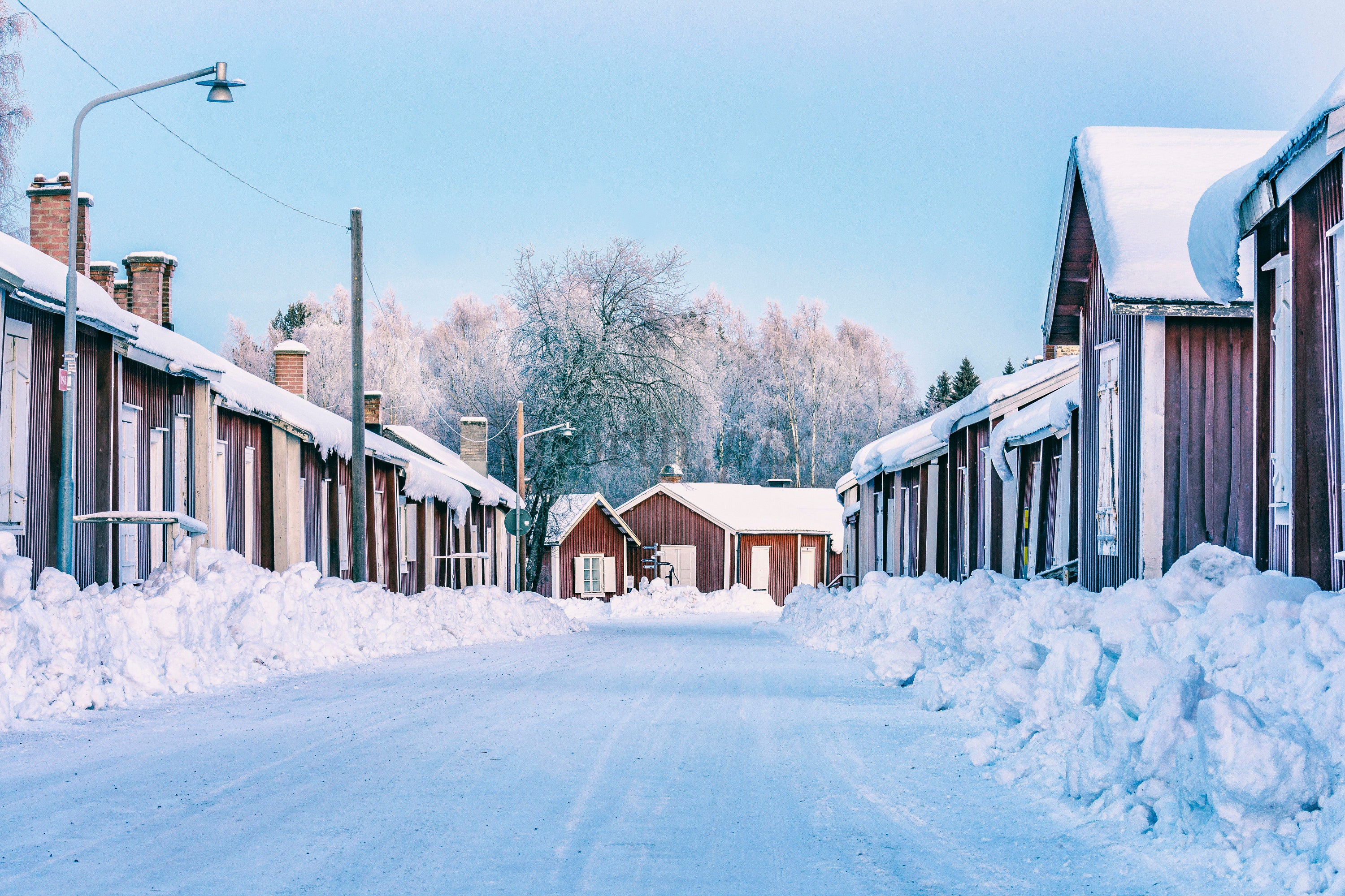 Row of wooden houses on snowy street, winter morning