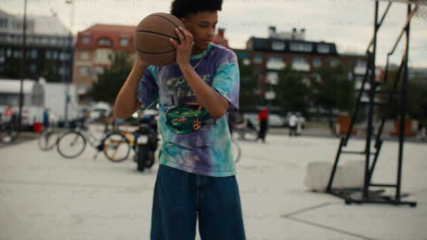 Young men playing one-on-one basketball on an urban court in Luleå