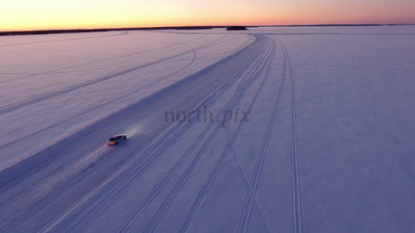 Car Driving on Ice Road at Sunset in Lulea Archipelago, Sweden
