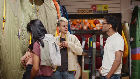 Friends Shopping for Camping Gear: Sleeping Bag Selection in Outdoor Retail Store