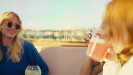 Friends Enjoying Drinks at Rooftop Bar in Lulea, Sweden, During Summer Evening