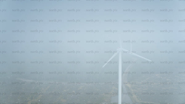 Wind turbine in foggy forest near ocean in Haraholmen