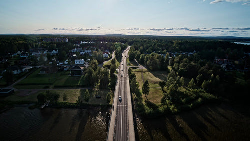 Flygfoto över Luleå, Sverige: Sommarkvällens biltur över bron, frodigt grönt landskap