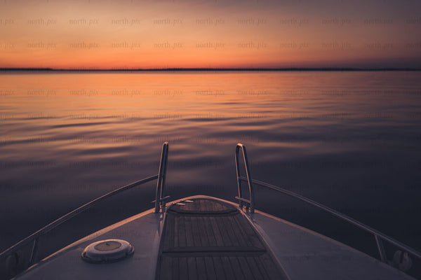 Boat bow at sunset over lake