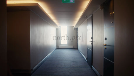 Businesswoman Walking Down Hotel Hallway with Luggage in Lulea