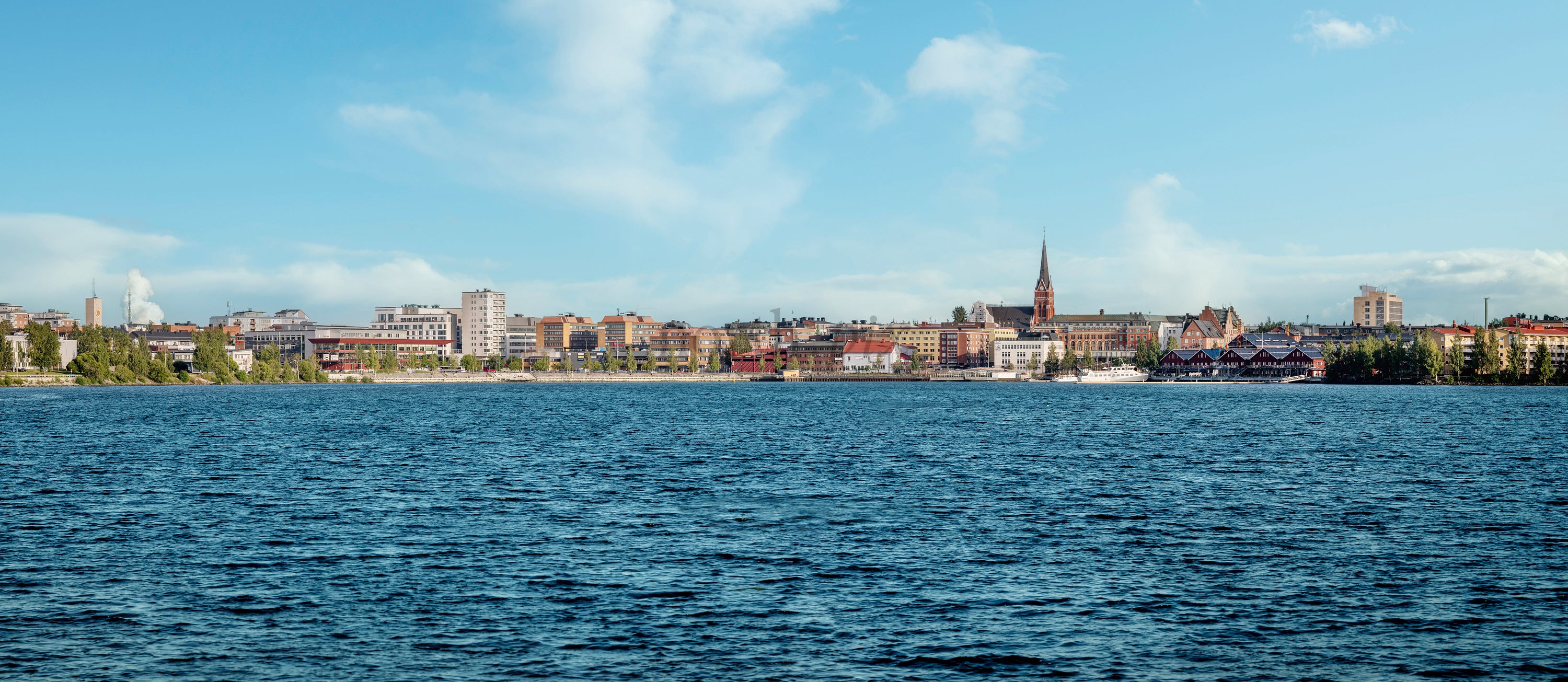 Summer city skyline across waterfront with church steeple