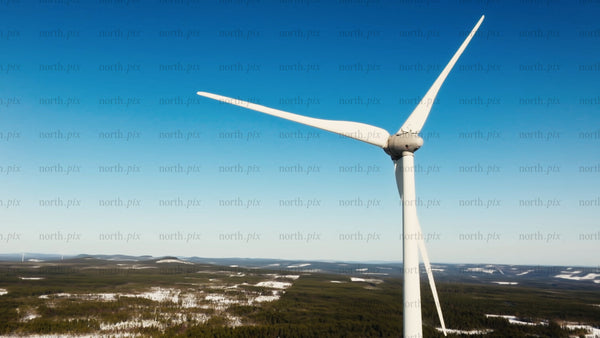 Close up of wind turbine in snowy Markbygden, winter, blue sky, aerial view