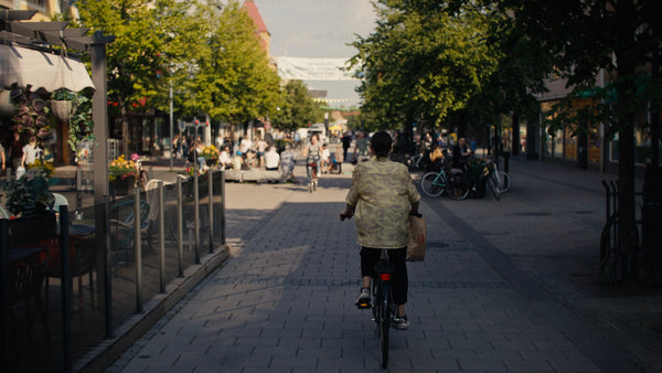 Woman on bicycle in Luleå city center during sunny summer day