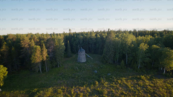 Aerial view of old windmill in forest clearing, Luleå, summer evening