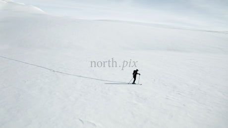 Lone Skier in Snowy Mountain Landscape: Winter Adventure