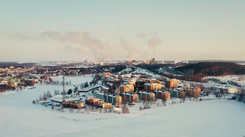 Flygfoto över Luleå, Sverige: Vinterlandskap, industriområde och bostadshus vid solnedgången
