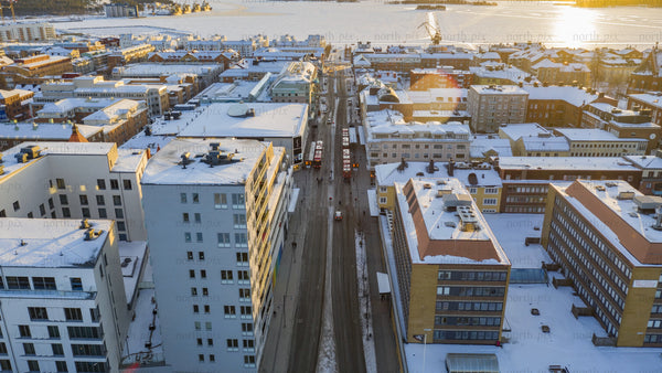 Luleå winter cityscape: Aerial drone timelapse of snowy streets and frozen river at sunset