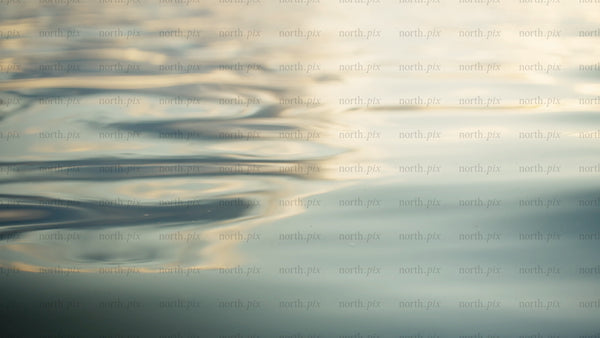 Golden light reflecting on calm water surface