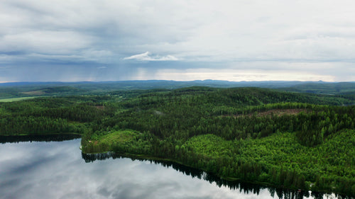 Flygfoto över Ubbynsjön och skogen på en molnig sommardag