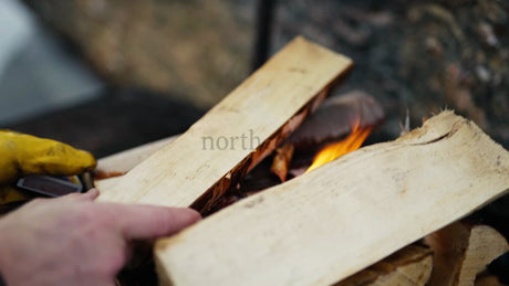Adding Firewood to a Winter Fire in the Luleå Archipelago, Sweden