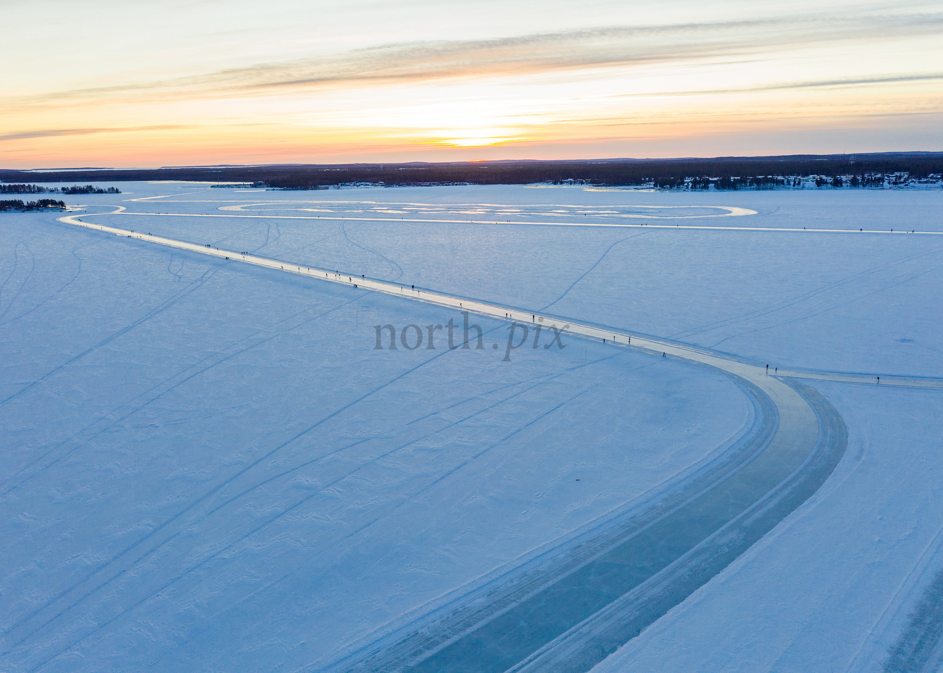 Winter Sunset Over Frozen Lake Captured Through Drone Aerial View