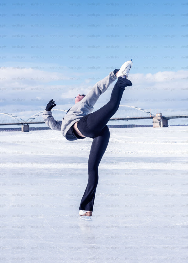 Figure skater on frozen river with bridge, winter morning