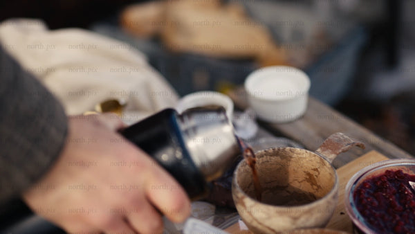 Winter picnic in the Luleå archipelago: Pouring a hot drink into a kuksa mug