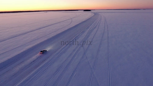 Bilkörning på isväg vid solnedgången i Luleå skärgård, Sverige