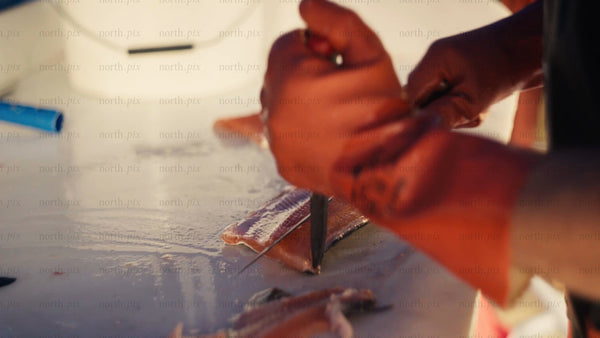 Fresh salmon filleting: Close-up of hands preparing fish in urban summer setting