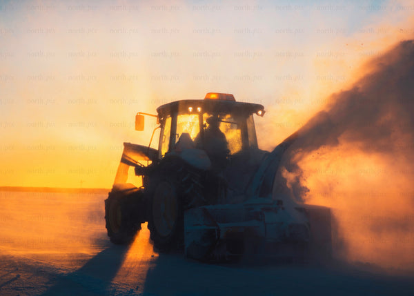 Snow removal tractor during sunrise winter landscape scene