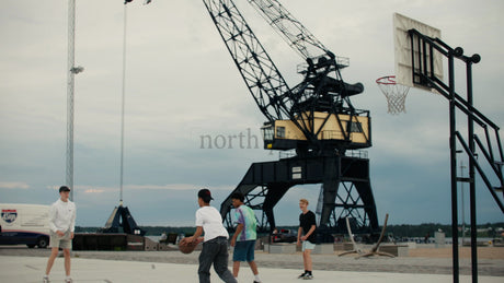 Friends Playing Basketball in Urban Luleå at Sunset, Capturing Summer Fun and Activity