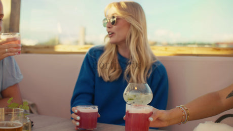 Friends Enjoying Drinks at a Rooftop Bar in Lulea, Sweden, During a Summer Sunset