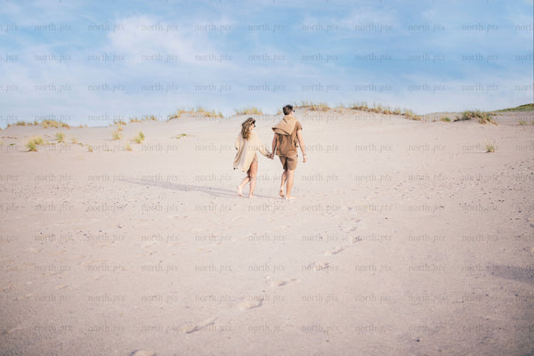 Couple walking on sand dunes at midday
